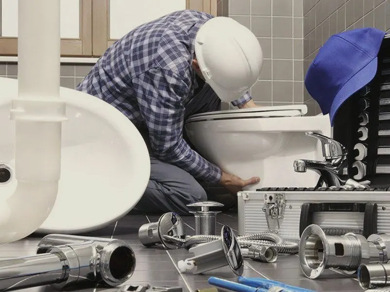 Un plombier casqué qui installe des WC