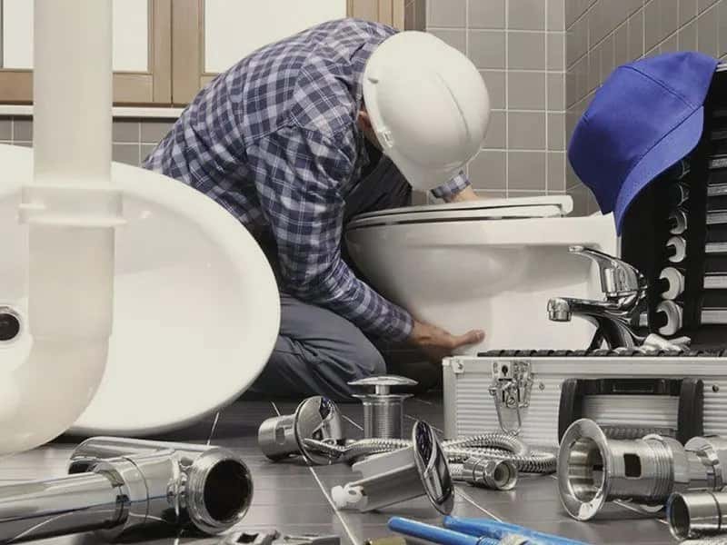 Un plombier casqué qui installe des WC